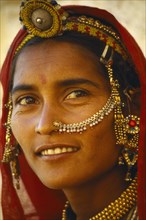 INDIA, Rajasthan, Body Decoration, Portrait of woman with ornate head and nose jewellery.