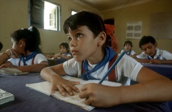 CUBA,  , Holguin, Children in classsroom writing whilst looking toward top of the class
