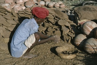 INDIA, Rajasthan, Work, Man making dung fuel.