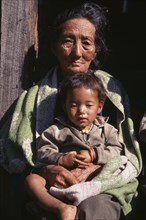 INDIA, Sikkim, People, "Woman holding child in her lap, head and shoulders portrait."
