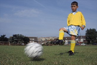 SPORT, Ball, Soccer, Young boy kicking football.