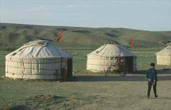 CHINA, Inner Mongolia, Man walking past two yurts