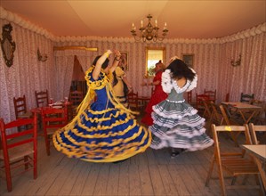 SPAIN, Andalucia , Seville, Three young girls in Flamenco dresses dancing in one of the tents at
