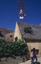 FRANCE, Aquitaine, Dordogne,  La Roque. Easter decorations attached to pole on exterior of house