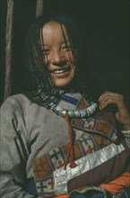 TIBET, Lhasa, Portrait of smiling girl wearing turquoise beads