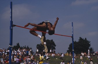 10048207 SPORT Athletics High Jump Competitor in men s high jump clearing bar.