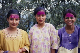 INDIA, Sikkim , Tashiding, Three young women with coloured rice on their foreheads for Diwali.