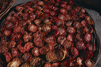 PAKISTAN, Hunza, Karimabad, "Sun dried tomatoes in large, shallow baskets."