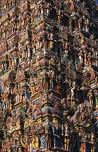 INDIA, Tamil Nadu, Madurai, Sri Meenakshi Temple.  Detail of ornately carved and painted exterior.