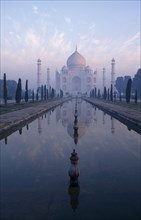 INDIA, Uttar Pradesh, Agra , Taj Mahal reflected in watercourse through formal gardens in pale pink