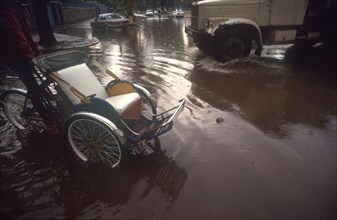 CAMBODIA, Phnom Penh, "Street near the Royal Hotel flooded after the monsoon rains.  Car, truck and