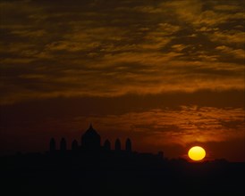 INDIA, Rajasthan, Jodphur, Umaid Bhawan Palace seen at sunset with orange setting sun