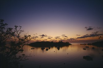 BERMUDA, Elys Harbour, Sunset over small island and moored boats