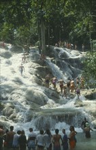 WEST INDIES, Jamaica, Ocho Rios, Dunns River Falls with tourists walking up through the pools