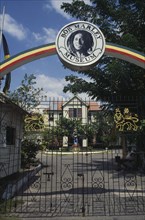 WEST INDIES, Jamaica , Kingston, Bob Marley Museum entrance with metal gate under archway.