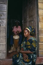 JAMAICA, Music, Percussion, Rastafarian couple with man playing bongo drums inside home while woman