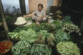 VIETNAM, Mekong Delta, Tay Ninh, Smiling woman at her vegetable stall in a street market