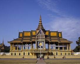 CAMBODIA, Phnom Penh, The Royal Palace.  Exterior and entrance gate with passing cyclists.
