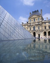 FRANCE, Ile de France, Paris, Louvre.  Cour Napoleon and glass pyramid reflected in water in