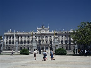 SPAIN, Madrid State, Madrid, Royal Palace. Tourists in square outside railings with gates