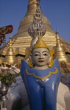 MYANMAR,  , Yangon, Schwedagon Pagoda temple detail with statue in the the foreground