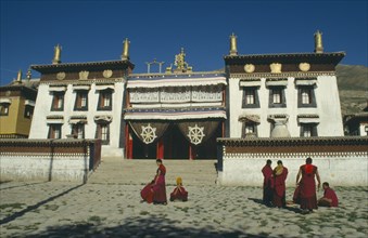 CHINA, Qinghai, Tongren , Tibetan Monastery with monks gathered outside