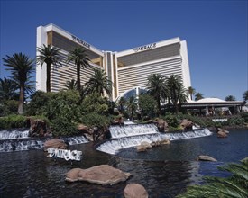USA, Nevada, Las Vegas, Mirage Hotel and Casino. View across waterfall and palm tree lined rock