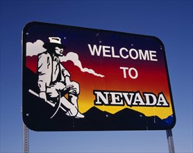 USA, Nevada, Welcome to Nevada roadsign with gold-digger looking across towards mountains and