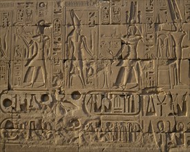 EGYPT, Nile Valley, Karnak, "Karnak Temple.  Hieroglyphic details carved in stone wall, people and