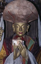 INDIA, Ladakh, "Buddhist temple statue of high ranking lama with money placed in its hands and