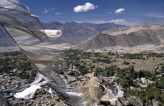 INDIA, Ladakh, Leh Valley , Prayer flags blowing in the wind above village and mountainous terrain