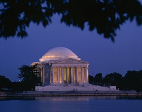 USA, Washington DC, Jefferson Memorial illuminated at night with a lake in the foreground seen