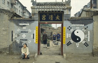 CHINA, Inner Mongolia, Hohhot, Monks or priests seen through the entrance of Daoist temple with
