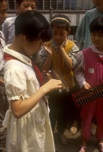 CHINA, Shaanxi, Xian, Young school girl using wooden abacus