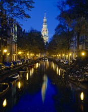 HOLLAND, North, Amsterdam, Zuiderkirk and Groenburger canals at night with reflected church and