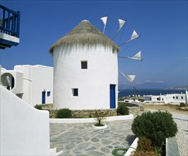 GREECE, Cyclades Islands, Mykonos, "White windmill with thatched roof, sails have flags at tips,