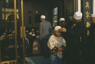 CHINA, Gansu Province, Lanzhou, Family outside mosque.