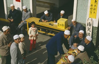 CHINA, Gansu Province, Lanzhou, Muslims outside mosque giving donations.