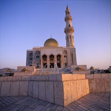 OMAN, Capital Area, Al Khuwair, Zawawi Mosque. Exterior seen at dusk with gold dome shining and