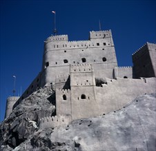 OMAN, Capital Area, Muscat  , Fort Jalali. Crenellated towers and walls built on rocky outcrop.