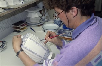 HOLLAND, Industry, Delftware, Female worker painting design onto delftware vase.