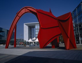 FRANCE, Ile de France, Paris, La Défense.  La Grande Arche framed by red modern sculpture.