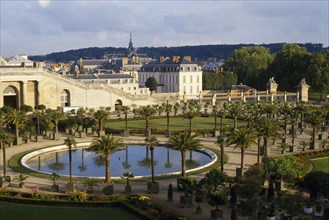 FRANCE, Ile de France, Versailles, General view over round pool surrounded by palms with the town