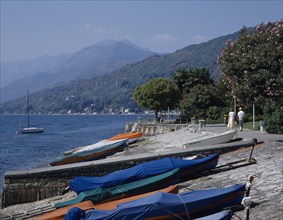 ITALY, Piedmont, Lake Maggiore , Pallanza. View along waterfront with covered boats on a slipway