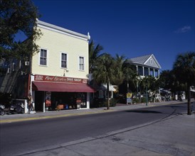 USA, Florida, Key West, View across an empty street lined with shopfronts including a Diving shop