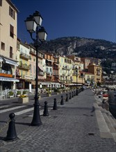 FRANCE, Alps Maritimes, Villefranche sur Mer, Quayside road lined with restaurants.