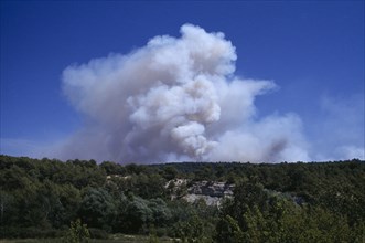 FRANCE, Provence Cote d’Azur, Luberon , Smoke from a forest fire rising from green landscape.