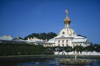 RUSSIA, St Petersburg, Petrodvorets, Yellow white and gold architecture seen across gardens and