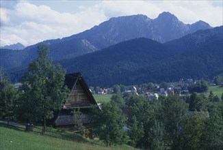POLAND, Tatra, Tatra Mountain range with wooden chalet roof in the foreground.