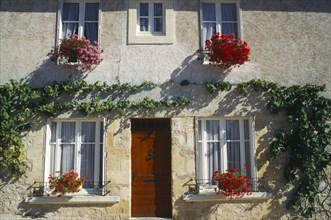 FRANCE, Aquitane, Villefranche du Perigord, House ifacade with hanging baskets in Bastide town